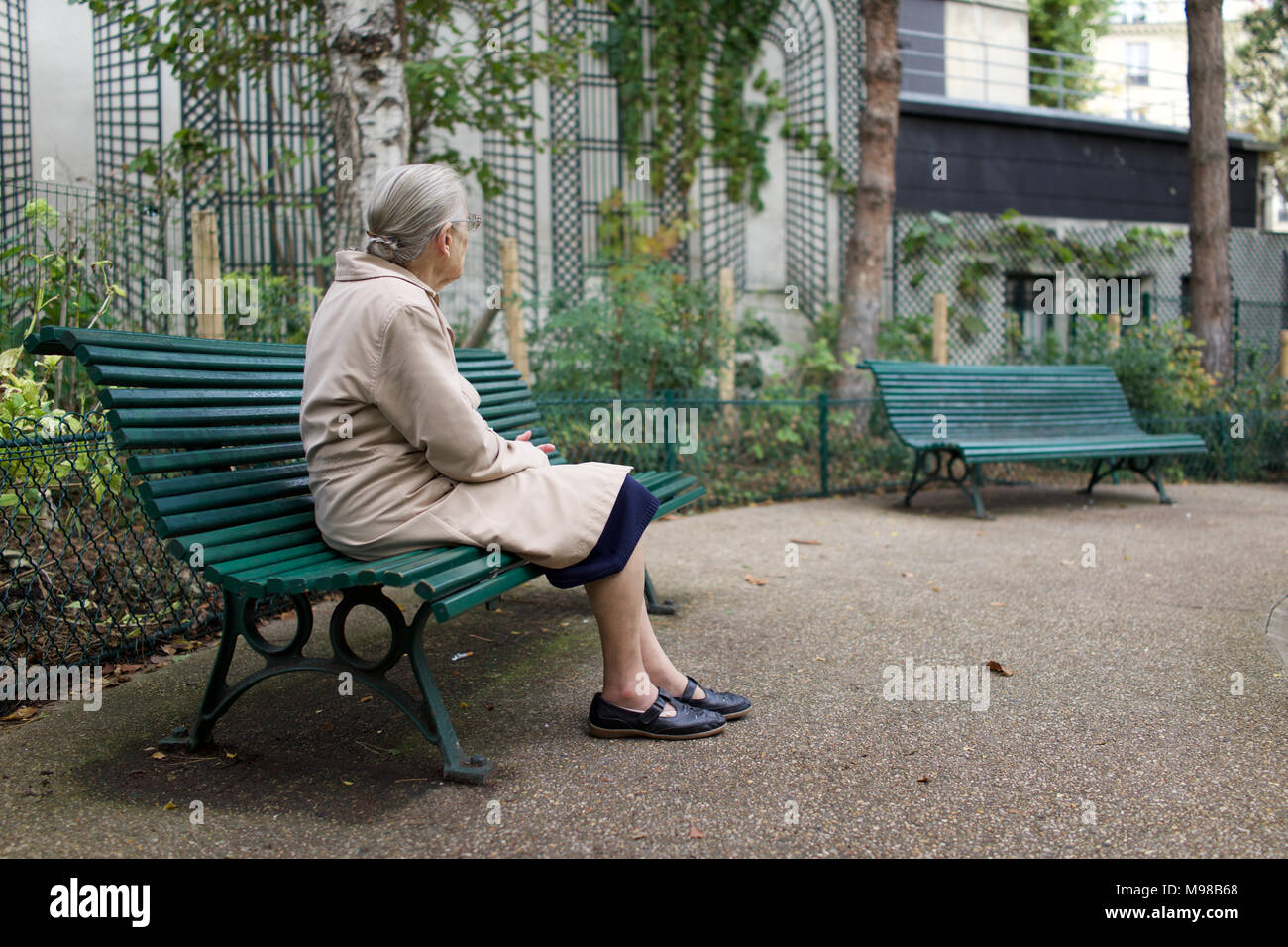 Einsame alte Dame sitzen auf einer Parkbank, Weg suchen, Paris Stockfoto