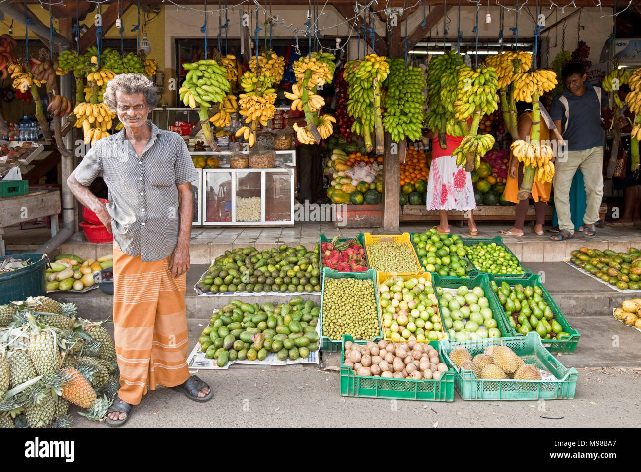 Eine lokale Sri Lankan Mann Mann auf dem niederländischen Markt steht stolz Lächeln für die Kamera außerhalb seiner Obst und Gemüse Laden in Galle, Sri Lanka. Stockfoto