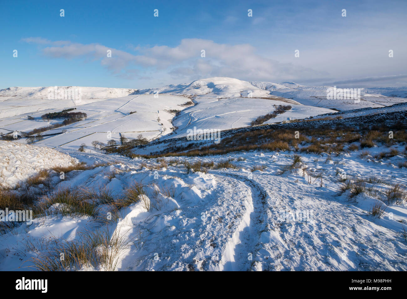 Wanderweg in der Nähe von Hayfield in den Hügeln des Peak District, Derbyshire. Ein schöner Wintermorgen. Die Hänge des Kinder Scout unter einer Schicht von Schnee. Stockfoto