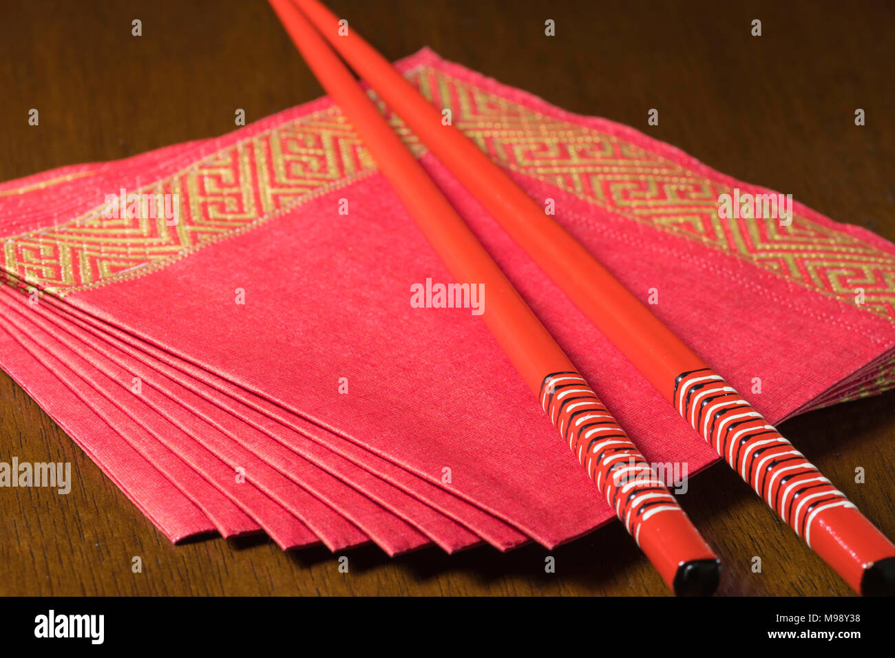 Dekoriert rot Papierservietten mit einem Paar rot lackierten Stäbchen Stockfoto