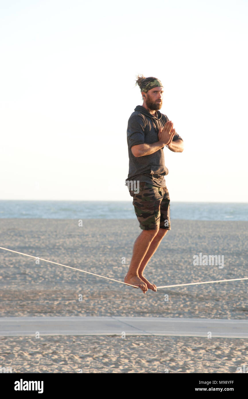 Man Balancieren auf Seil am Santa Monica Beach in Los Angeles, CA Stockfoto