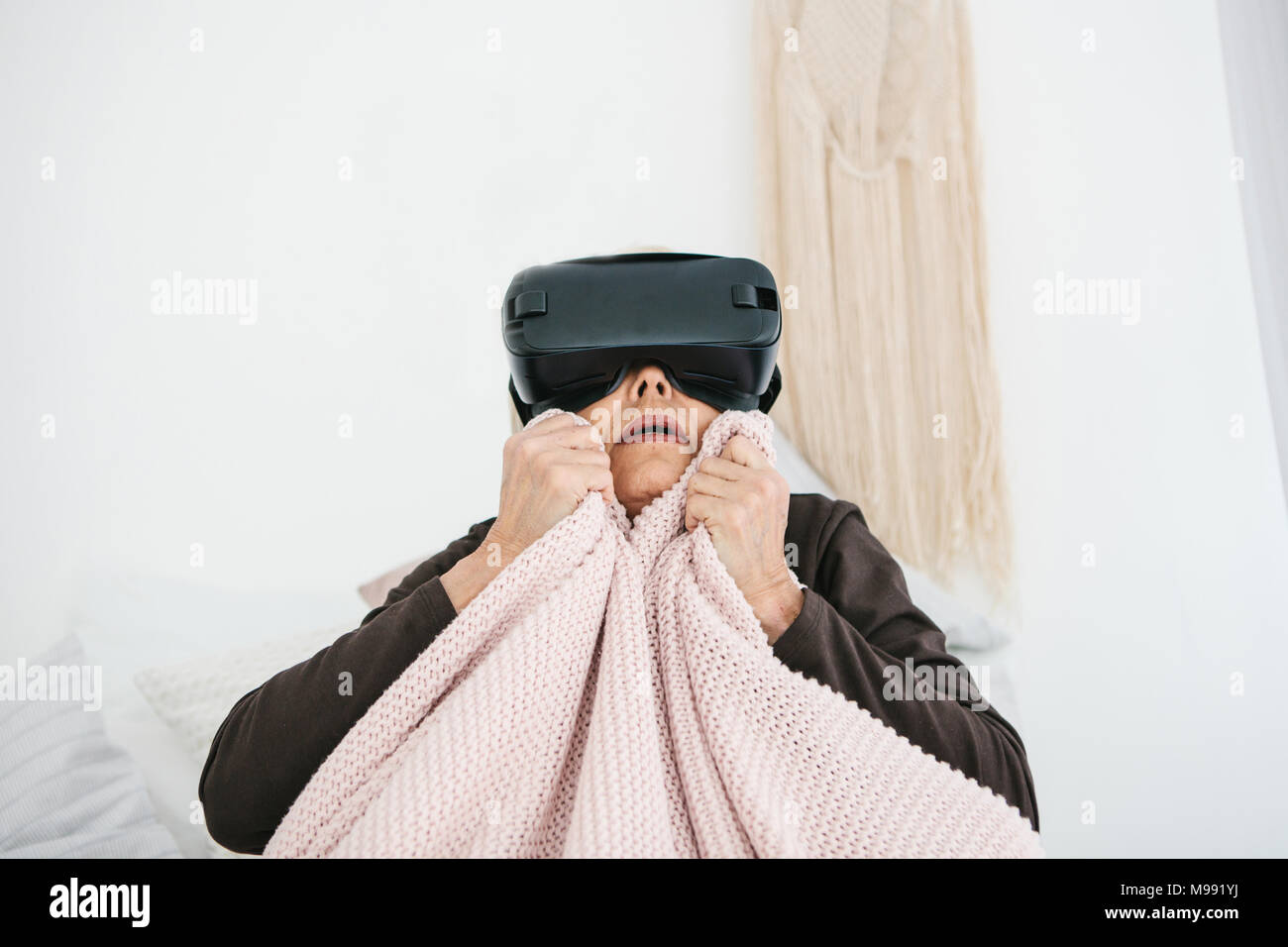 Eine ältere Frau in der virtuellen Realität Gläser. Eine ältere Person mit moderner Technologie. Stockfoto