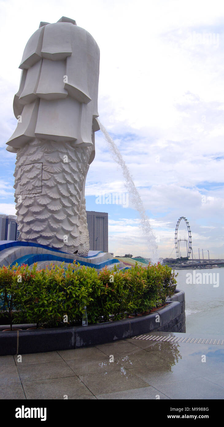 Singapur - APR 2 2015: Der Merlion Brunnen und die Skyline von Singapur. Merlion ist ein Fabelwesen mit dem Kopf eines Löwen und der Körper eines Fisches. Als Symbol der Stadt gesehen Stockfoto