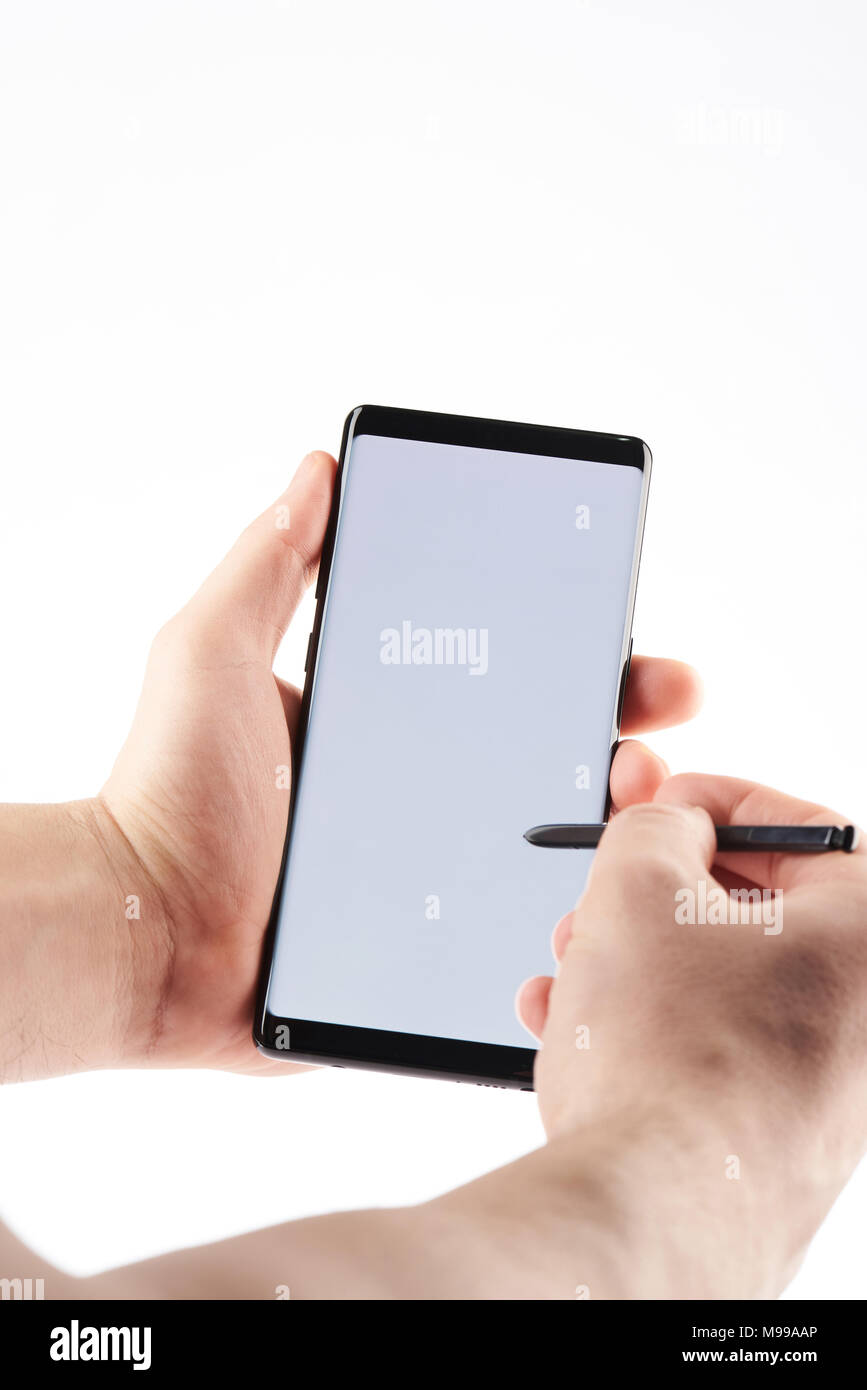 Berühren Smartphone mit Stift auf weißem Hintergrund Stockfoto
