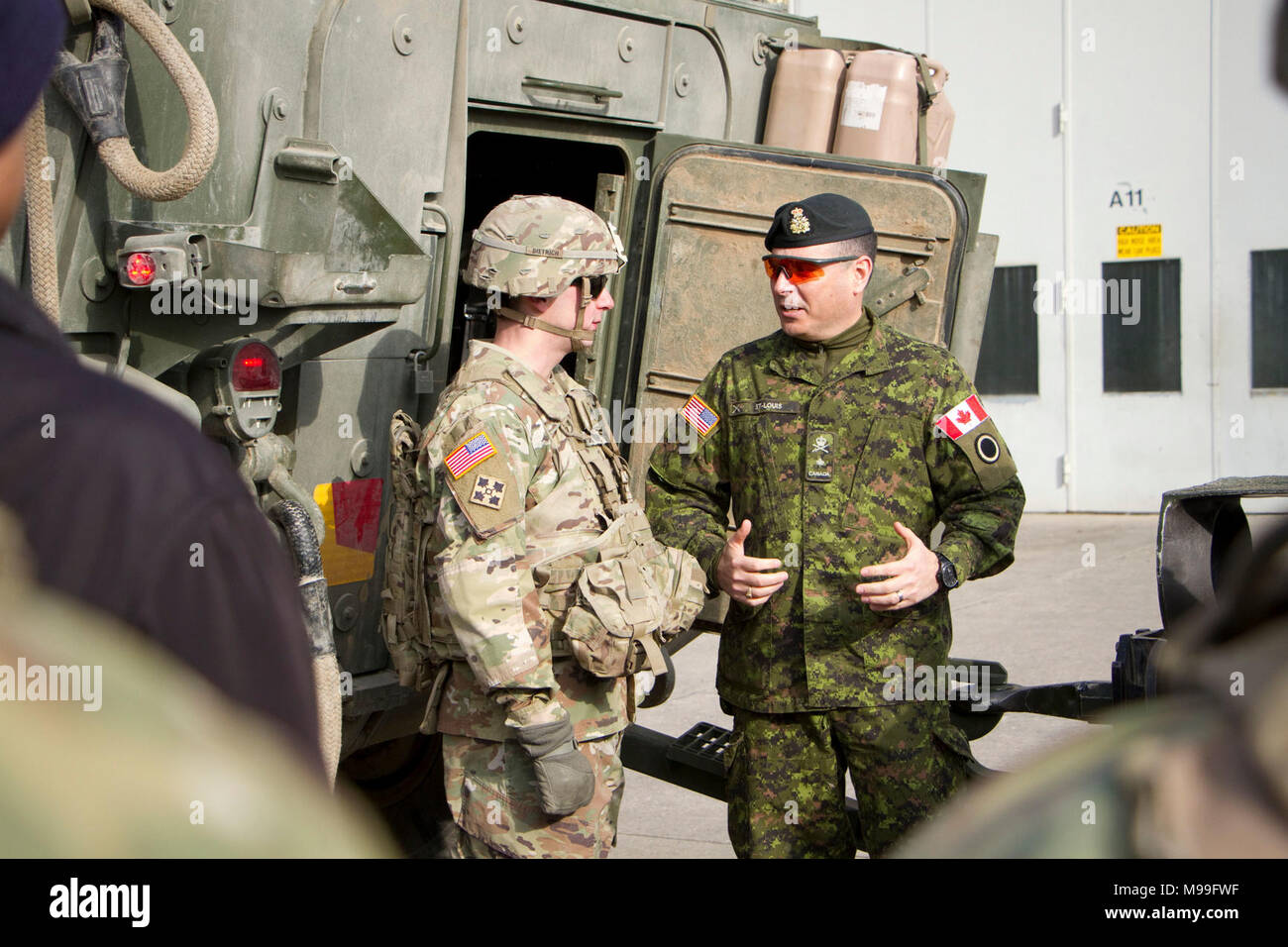 Brig. Gen. Michel-Henri St. Louis (Kanada), Stellvertretenden Kommandierenden General für den Betrieb von I Korps am Joint Base Lewis-McChord, Washington spricht mit Personal. Sgt. Colt Dietrich, eine haubitze Section Chief, Archer Batterie, Field Artillery Squadron, 2d-Cavalry Regiment zugeordnet, darüber, wie gut ein Stryker bekämpfen Fahrzeug schleppt ein M777 Haubitze. Dietrich Feedback gegeben, wie ein Stryker müssten geändert werden, ein howitzer Crew und ihrer Ausrüstung während einer Mission zu erfüllen. Die Präsentation fand am Februar 22, 2018 an das FA Elektromotor-pool. ( Stockfoto