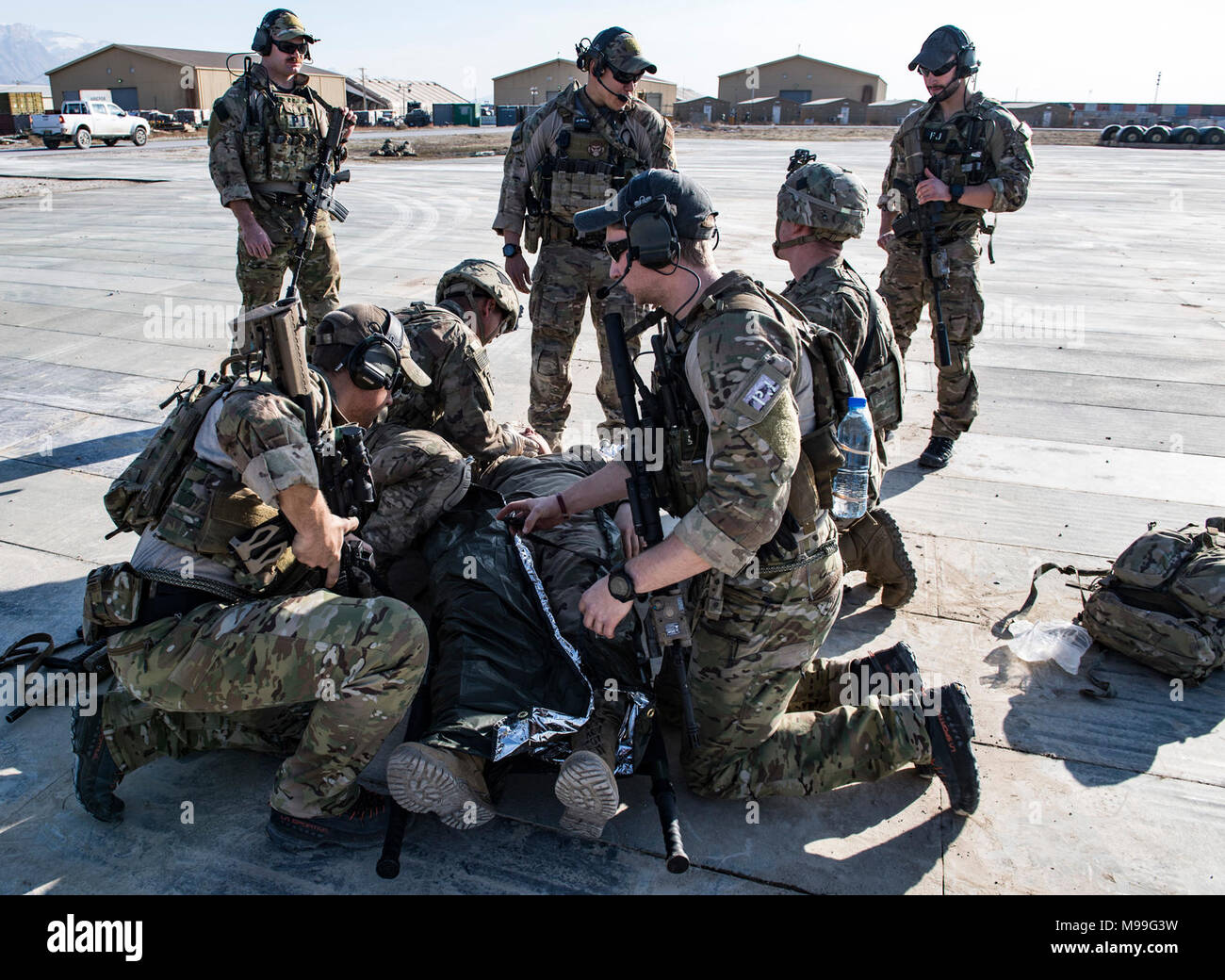 Us Air Force pararescuemen, die 83Rd Expeditionary Rescue Squadron zugeordnet, beobachten Sie medizinische Verfahren, die von den Mitgliedern der US-Army Aviation Eingreiftruppe vorgeformte, Task Force Schläger auf der Flightline am Flughafen Bagram, Afghanistan, Jan. 22, 2018. Die Beziehung zwischen der Armee und Luftwaffe Schutzengel Teams stellt die Grundlage für die künftige gemeinsame Personal Recovery Operationen, die in der Lieferung von entscheidender Airpower für US Central Command, alliierten Nationen und Amerika. (U.S. Air Force Stockfoto