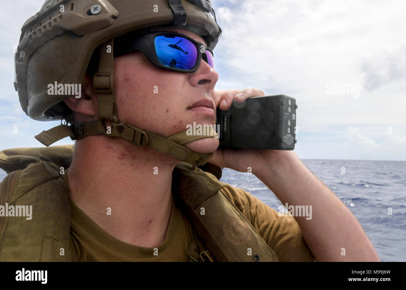 Engineman 3. Klasse Broderick Vaclavik, an die in den Küstenzonen Riverine Squadron (CRS) 4, Det zugeordnet. Guam, pflegt die Kommunikation mit einem MH-60S Sea Hawk Hubschrauber von der "Insel der Ritter" Hubschrauber Meer Combat Squadron (HSC) 25 an Bord eines Mark VI Patrouillenboot bei einer gemeinsamen Suche und Rettung Übung mit der U.S. Coast Guard Sektor Guam, Feb 23, 2018. CRS-4, an die in den Küstenzonen Riverine Gruppe 1, Det zugeordnet. Guam, ist in der Lage, leitende Maritime Security Operations in das gesamte Spektrum der Naval, Joint und Combined Operations. Es bietet zusätzliche Funktionen der Gefahrenabwehr, Secur eingeleitet Stockfoto