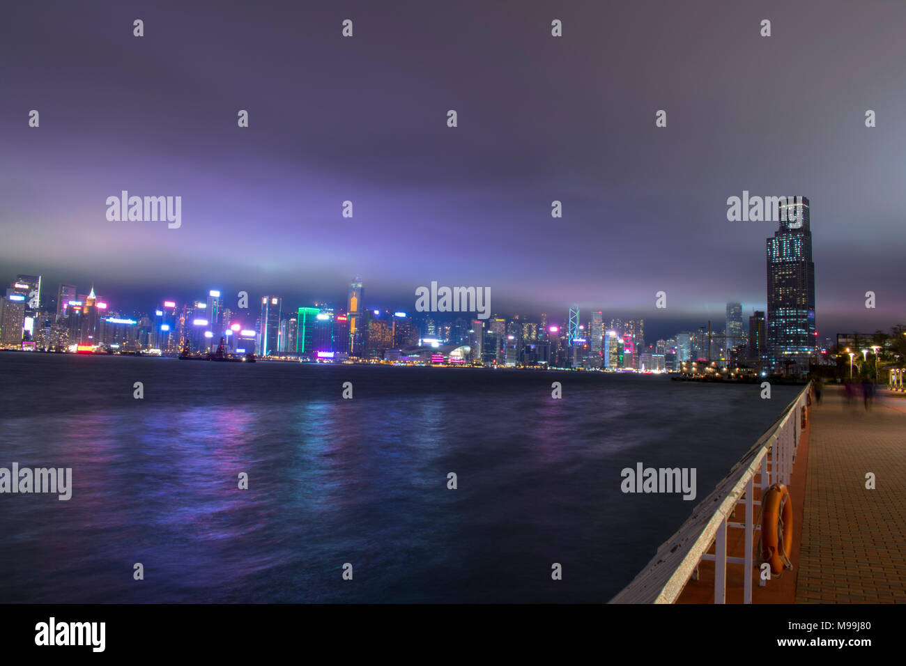 Hong Kong, Kowloon Bay, mit Blick auf die Stadt über den Fluss mit Menschen in Bewegung durch. Stockfoto