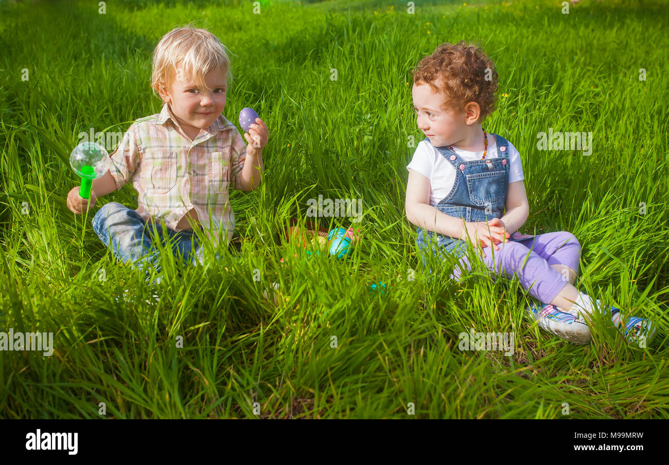 Zwei adorable Kleinkinder spielen mit zu Ostern Eier Jagd Stockfoto