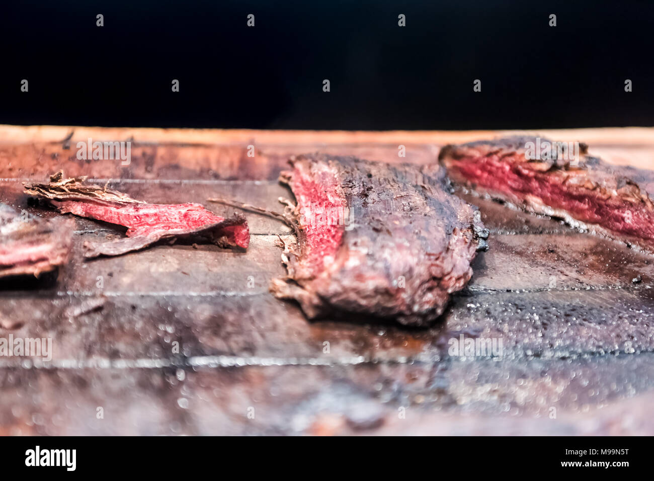 Frisch gebratenen roten vom Grill zubereitet gebräunt Rock Flanke Strip Steak auf Holz Schneidebrett, Fett, gut mariniert Stockfoto