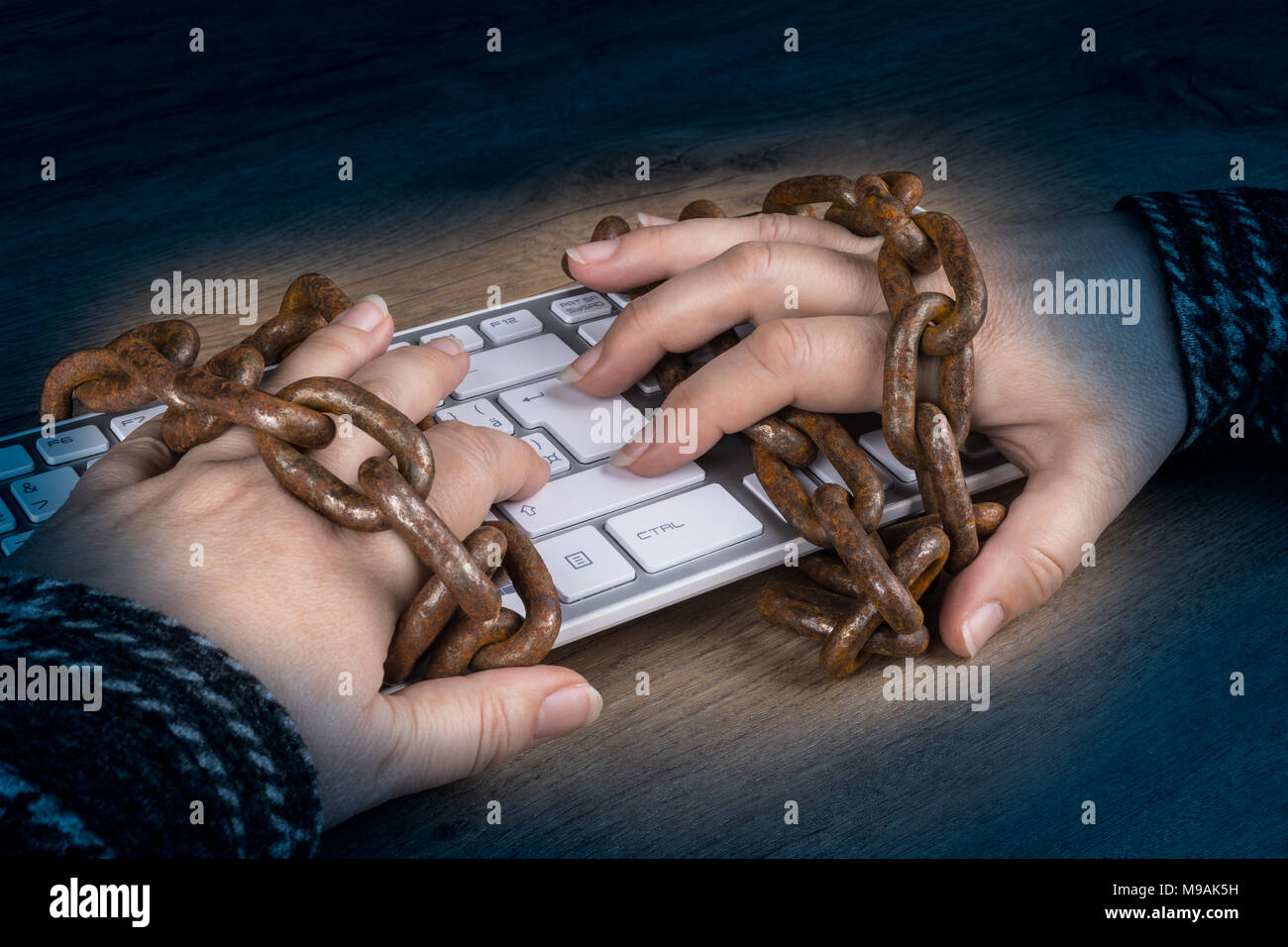 Nahaufnahmen der Hände, Tastatur und alten rostigen Ketten auf dunklen Hintergrund. Zensur, Spy, Digitalisierung, Cyber Security, den Schutz personenbezogener Daten - Bipr. Stockfoto