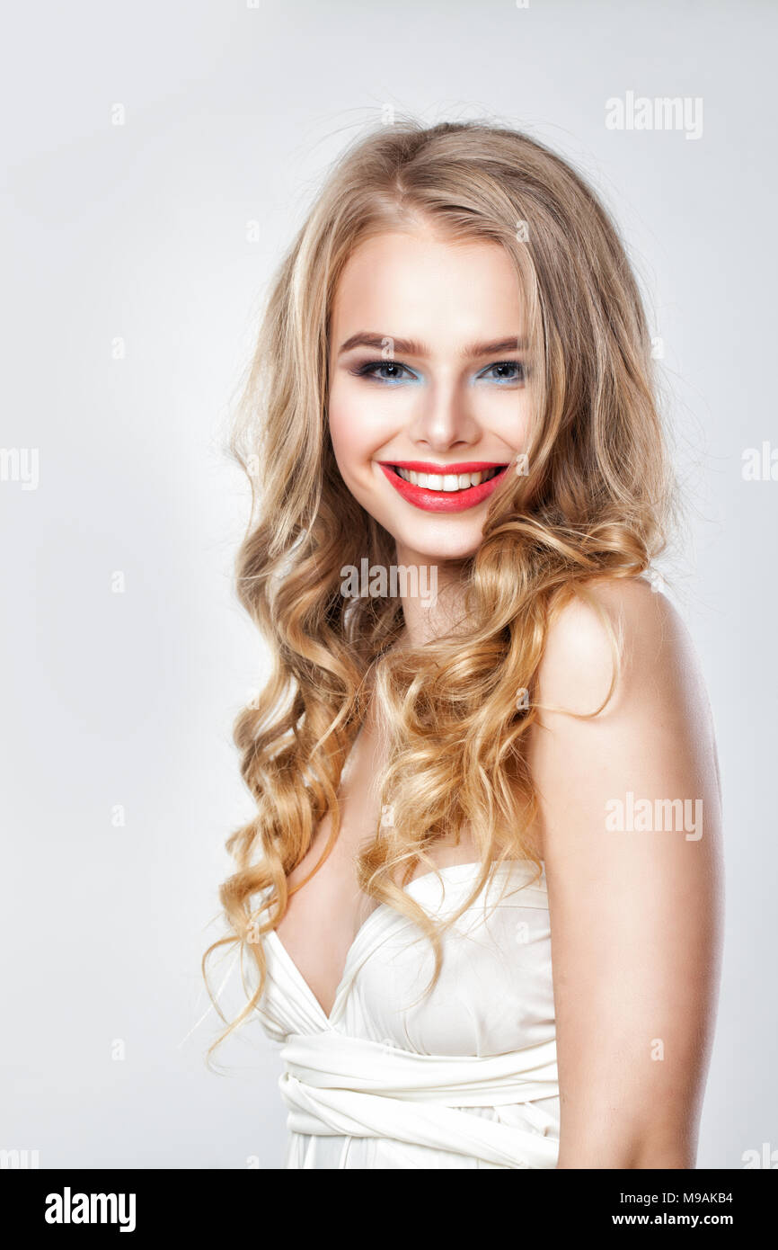 Perfekte Mode Modell Frau mit blonden dauergewelltes Haar. Portrait von Süß lächelnde Mädchen Stockfoto