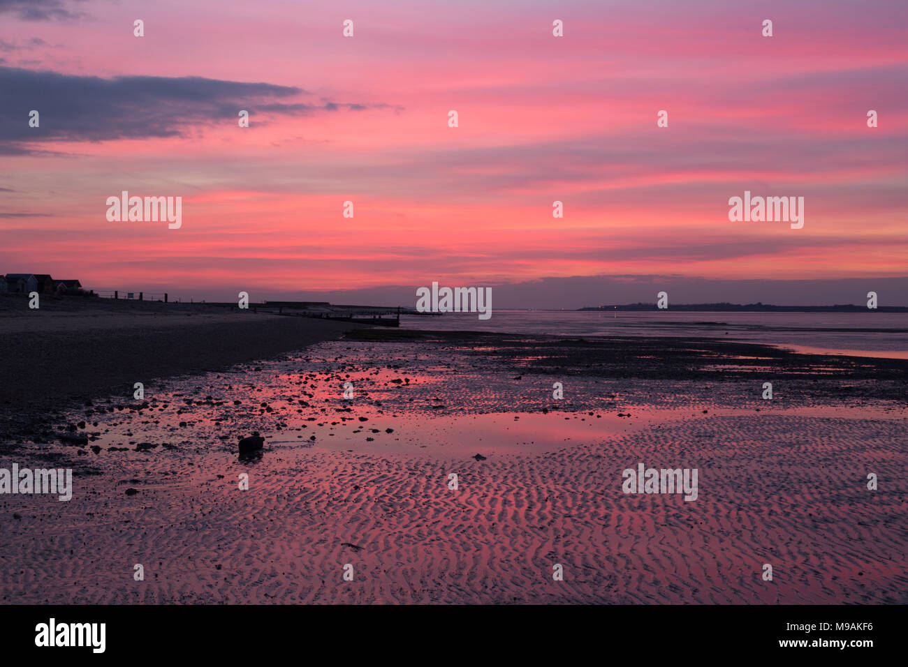 Rosa Sonnenuntergang am Strand, Seasalter Whitstable, Kent, UK, März 2018 mit Blick auf die Swale Mündung in Richtung der Insel Sheppey. Stockfoto