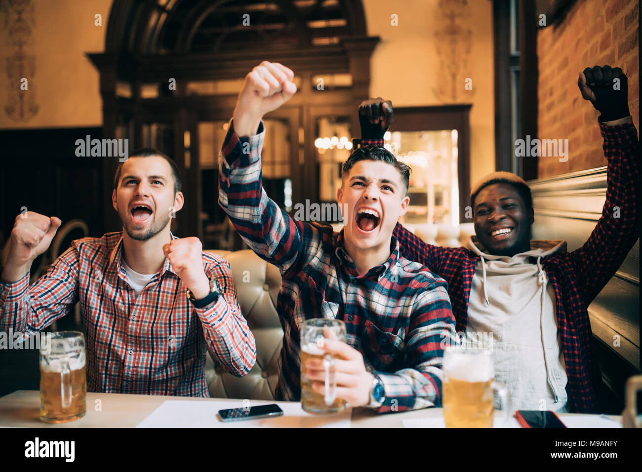Gerne Fußball-Fans oder männlichen Freunden Bier trinken und feiern Sieg an der Bar oder pub Stockfoto