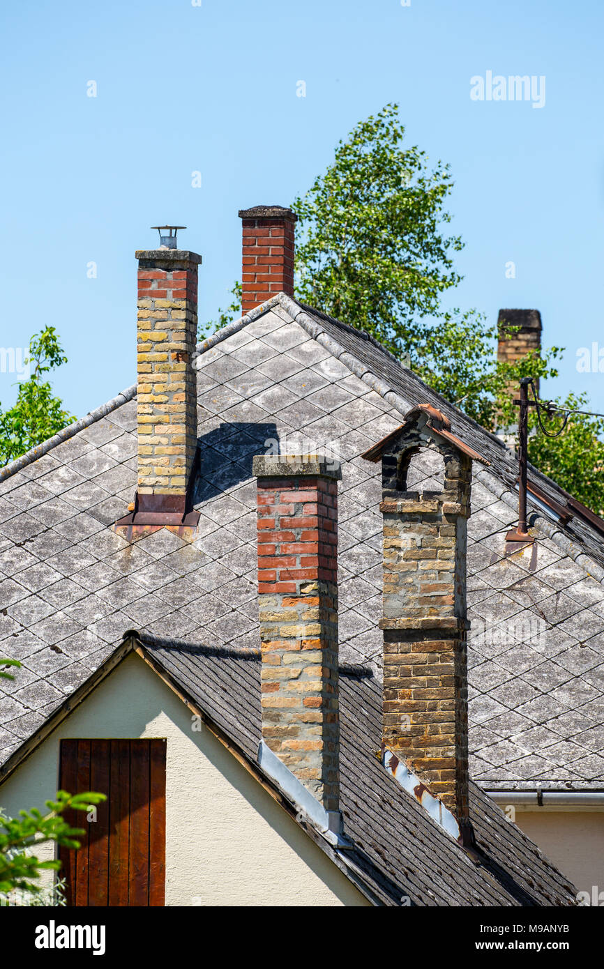 Schornsteine auf dem Schiefer Dach eines alten Hauses Stockfoto