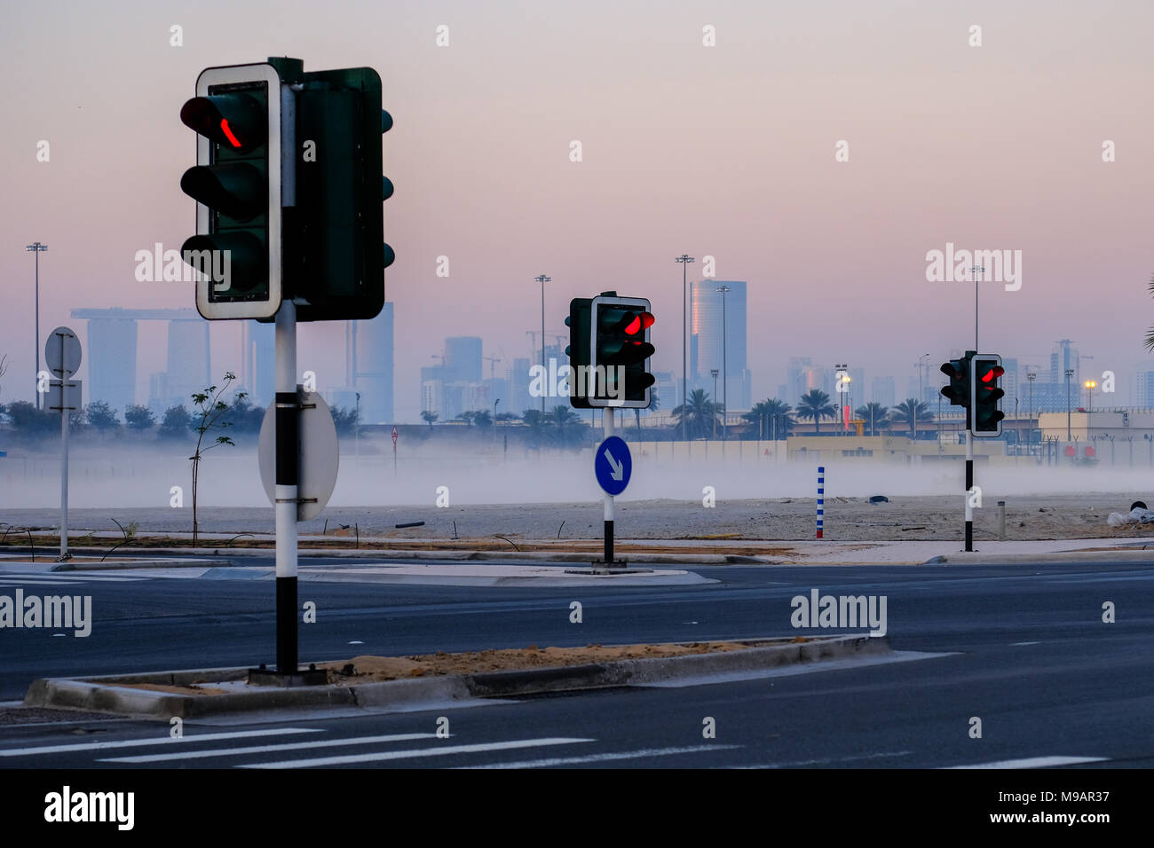 Ampel Beiträge, in einem mysty Morgen mit städtischen Gebäude in einem Abstand erfasst, Abu Dhabi, VAE. Stockfoto
