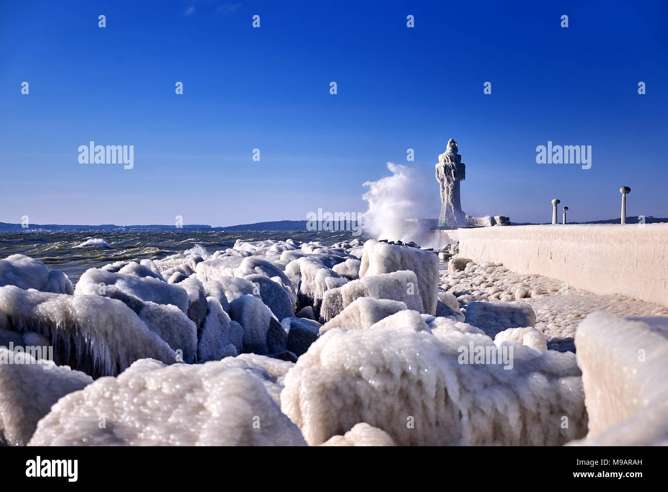 Gefrorene Leuchtturm und Mole an stürmischen Wintertag Stockfoto