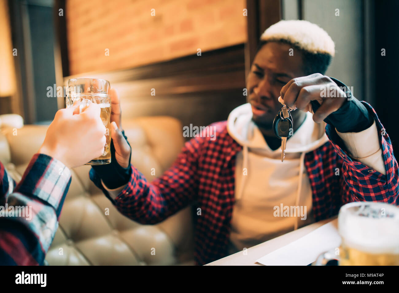 Junge afro-amerikanische Mann hält Autoschlüssel und die Ablehnung von Bier aus seinem Freund in der Kneipe zu trinken. Stockfoto