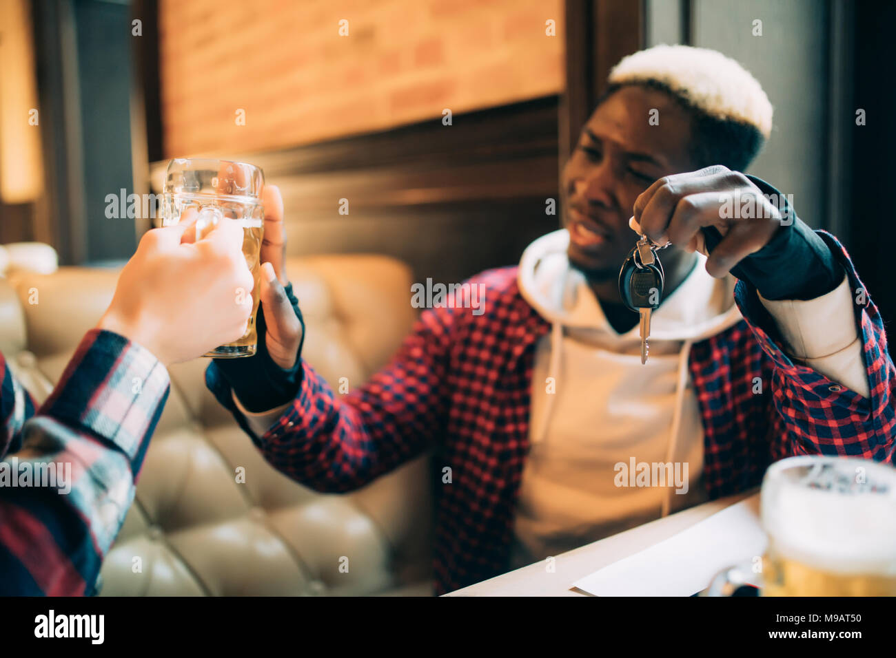 Junge afro-amerikanische Mann hält Autoschlüssel und die Ablehnung von Bier aus seinem Freund in der Kneipe zu trinken. Nicht trinken und fahren. Stockfoto