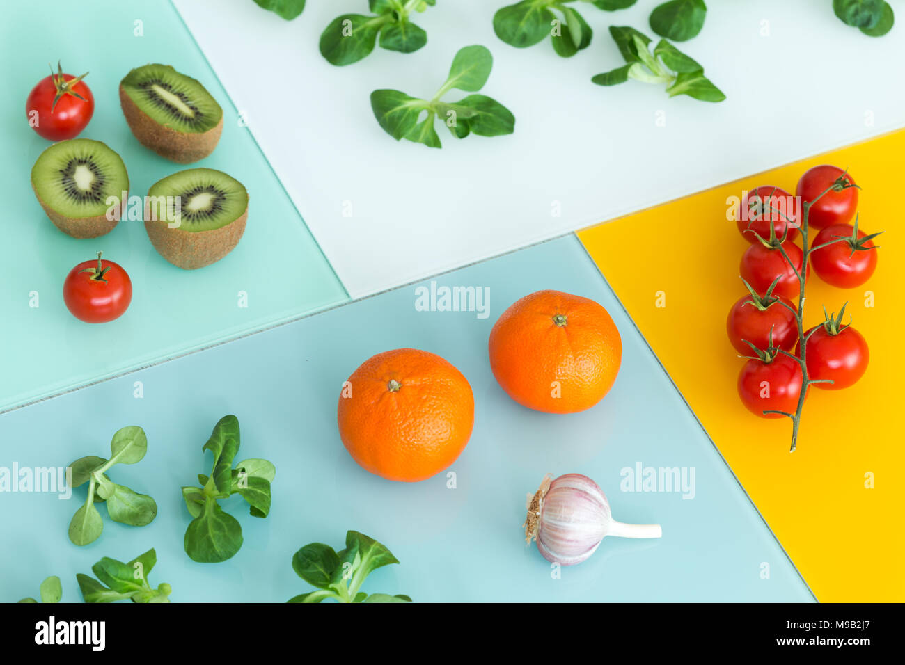 Obst und Gemüse verschiedener Arten auf einem farbigen Hintergrund Stockfoto