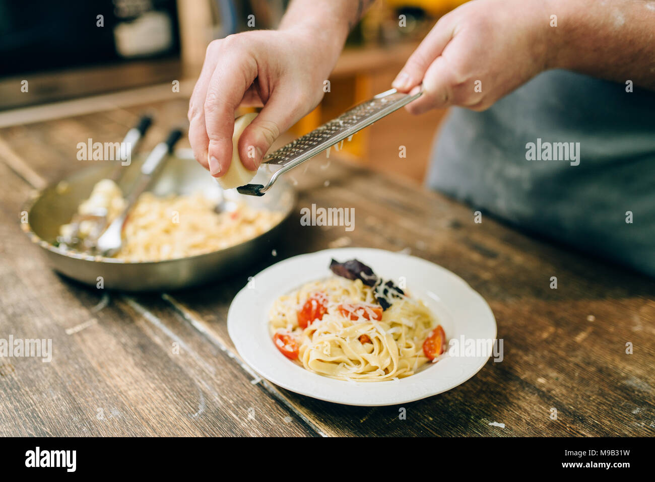 Koch Roste Käse in der Platte mit Fettuccine Stockfoto