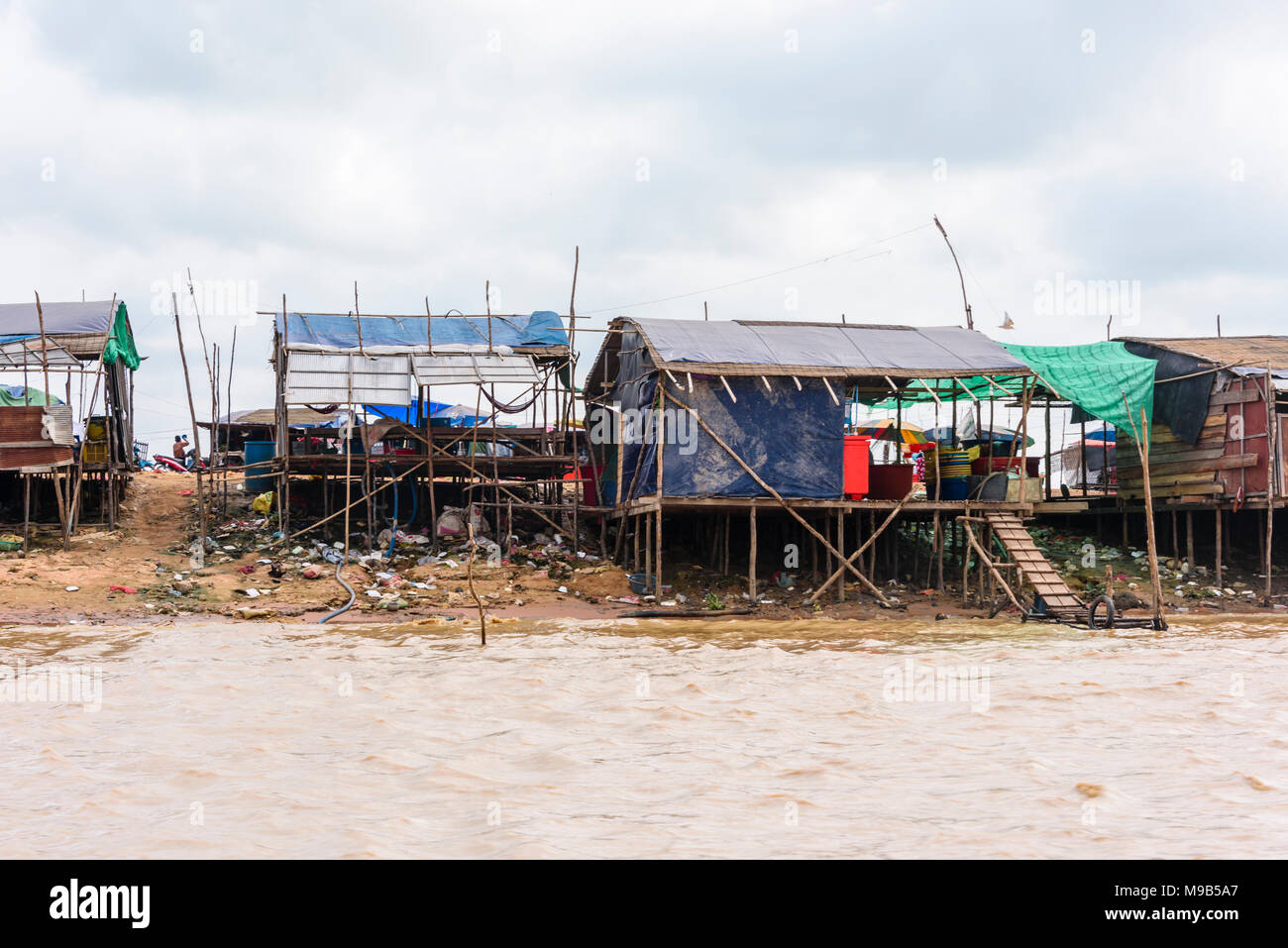 Häuser aus Plane, Wellblech und Bambus Matten am Ufer des Fluss Siem Reap, Kambodscha. Stockfoto