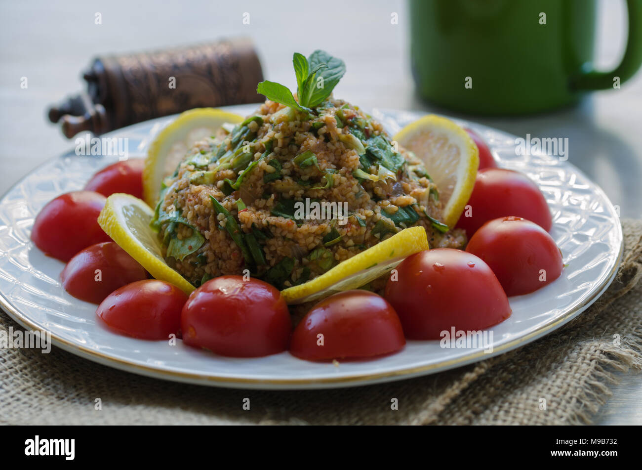 Salat mit Gemüse, Salat, grüne Zwiebeln, Tomatenmark, Öl und Bulgur und Tomaten Stockfoto