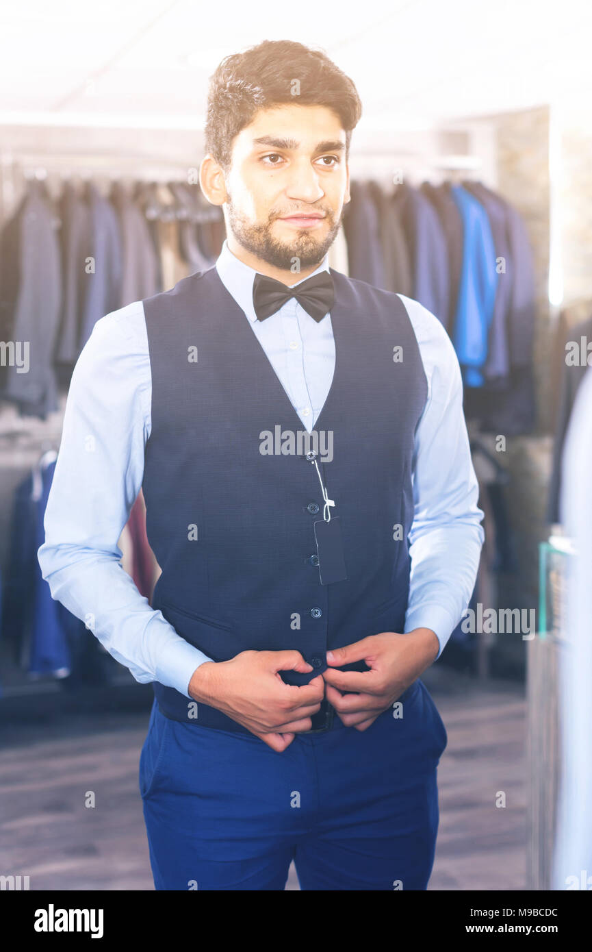 Mann versucht, der auf ausgewählten Bild vor dem Spiegel in der Männer Shop. Stockfoto