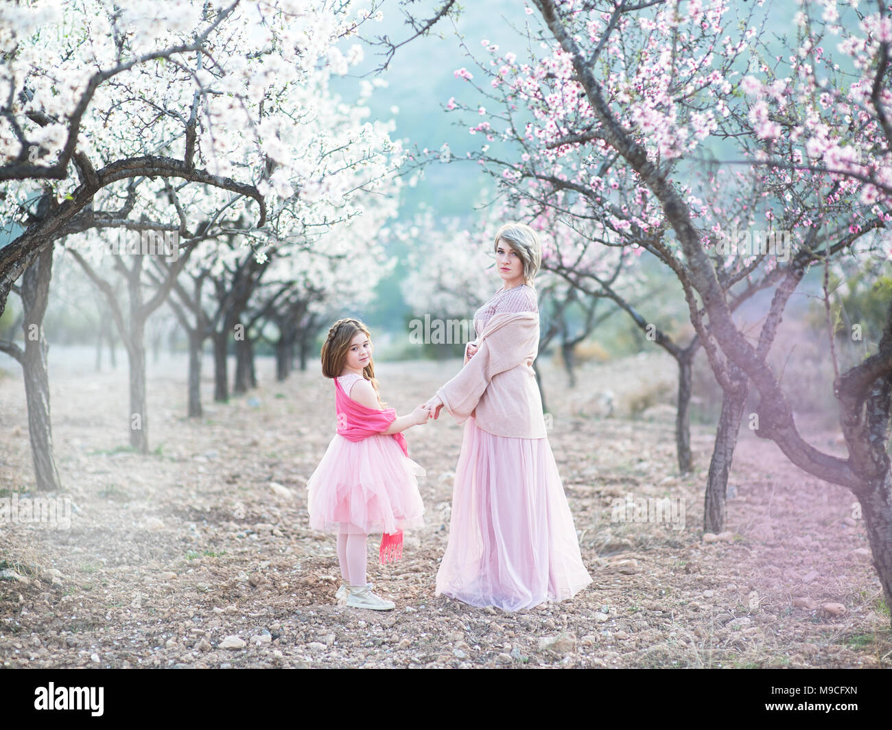 Mutter mit ihrer Tochter in der Blüte pfirsich Garten. Stockfoto