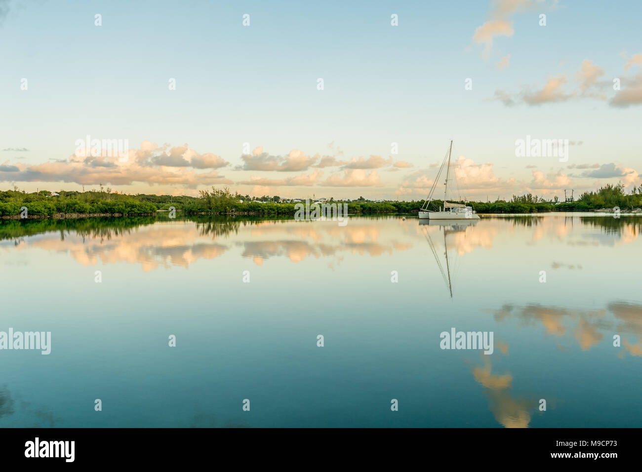 Salz Wasser See an einem schönen sonnigen windstillen Tag übersicht Segelboote mit Spiegel Reflexion auf See Wasser und Mangroven auf dem Hintergrund Stockfoto