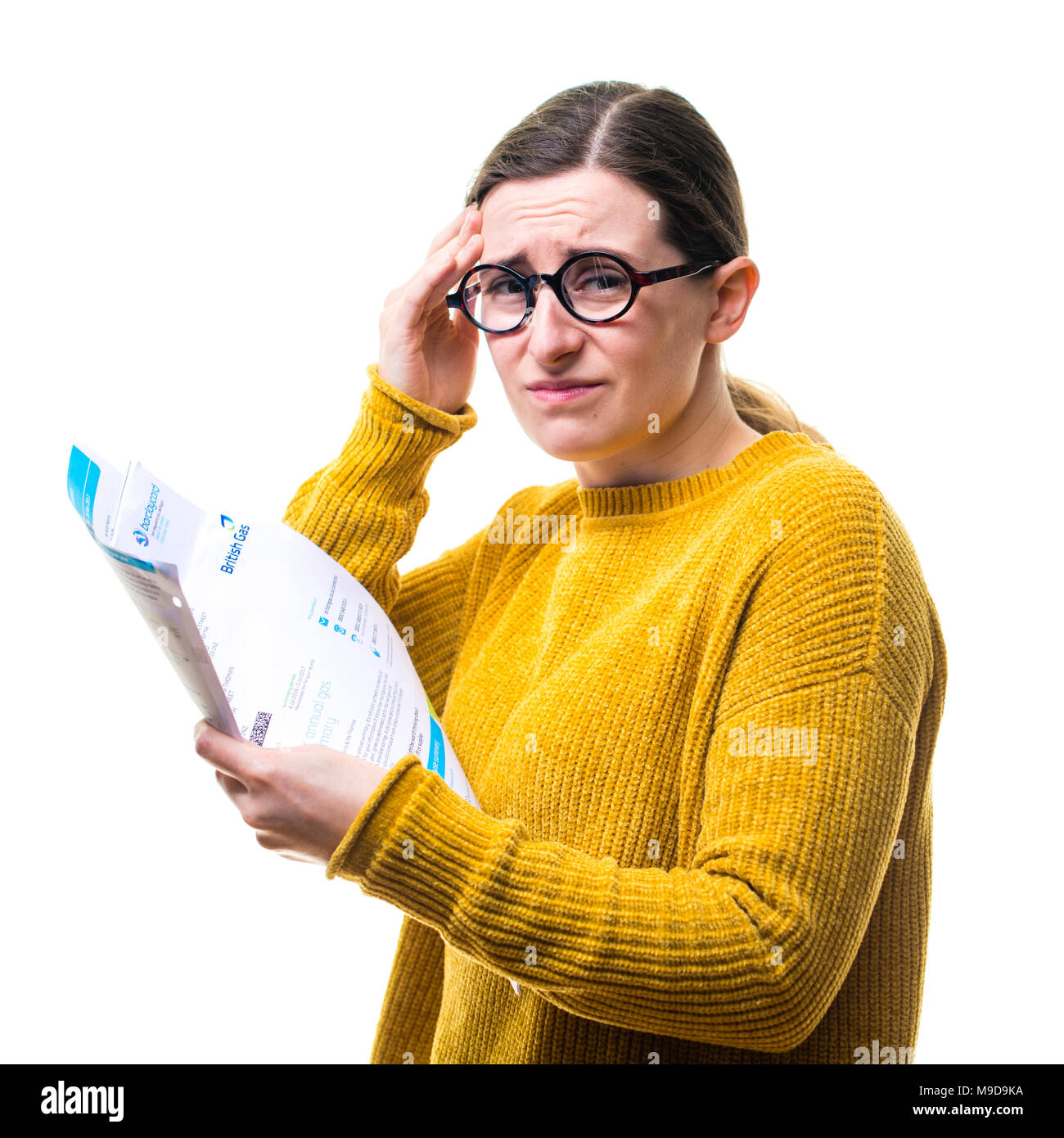 Eine junge Kaukasier Frau Mädchen mit einem gelben Pullover Pullover, besorgt über das Zahlen von inländischen Stromversorgung Rechnungen, vor einem weißen Hintergrund, Großbritannien Stockfoto
