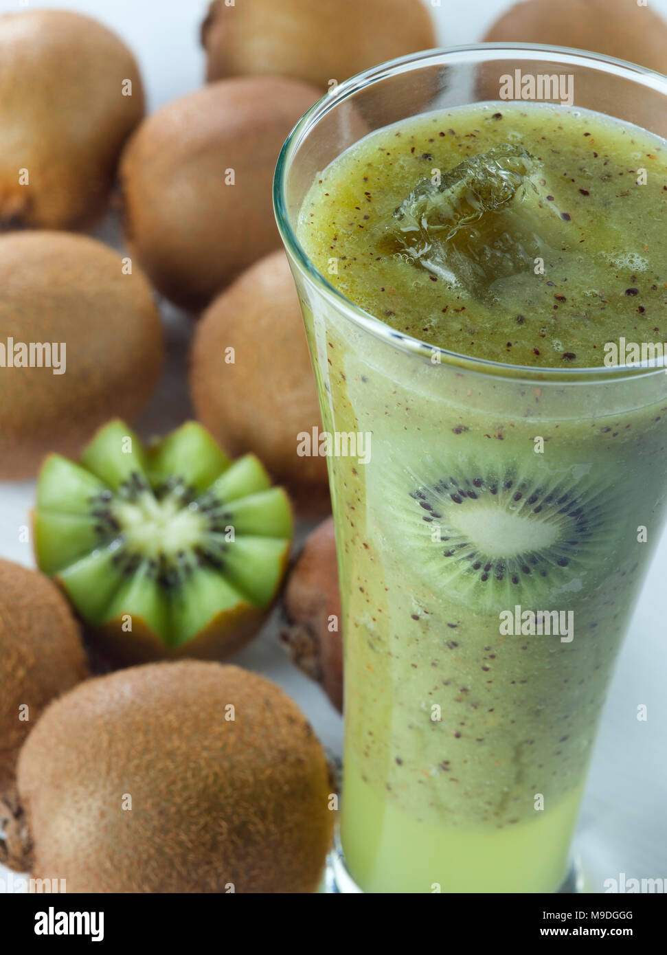 Ein Glas kiwi Saft schließen oben mit Schichten und Früchte im Hintergrund Stockfoto
