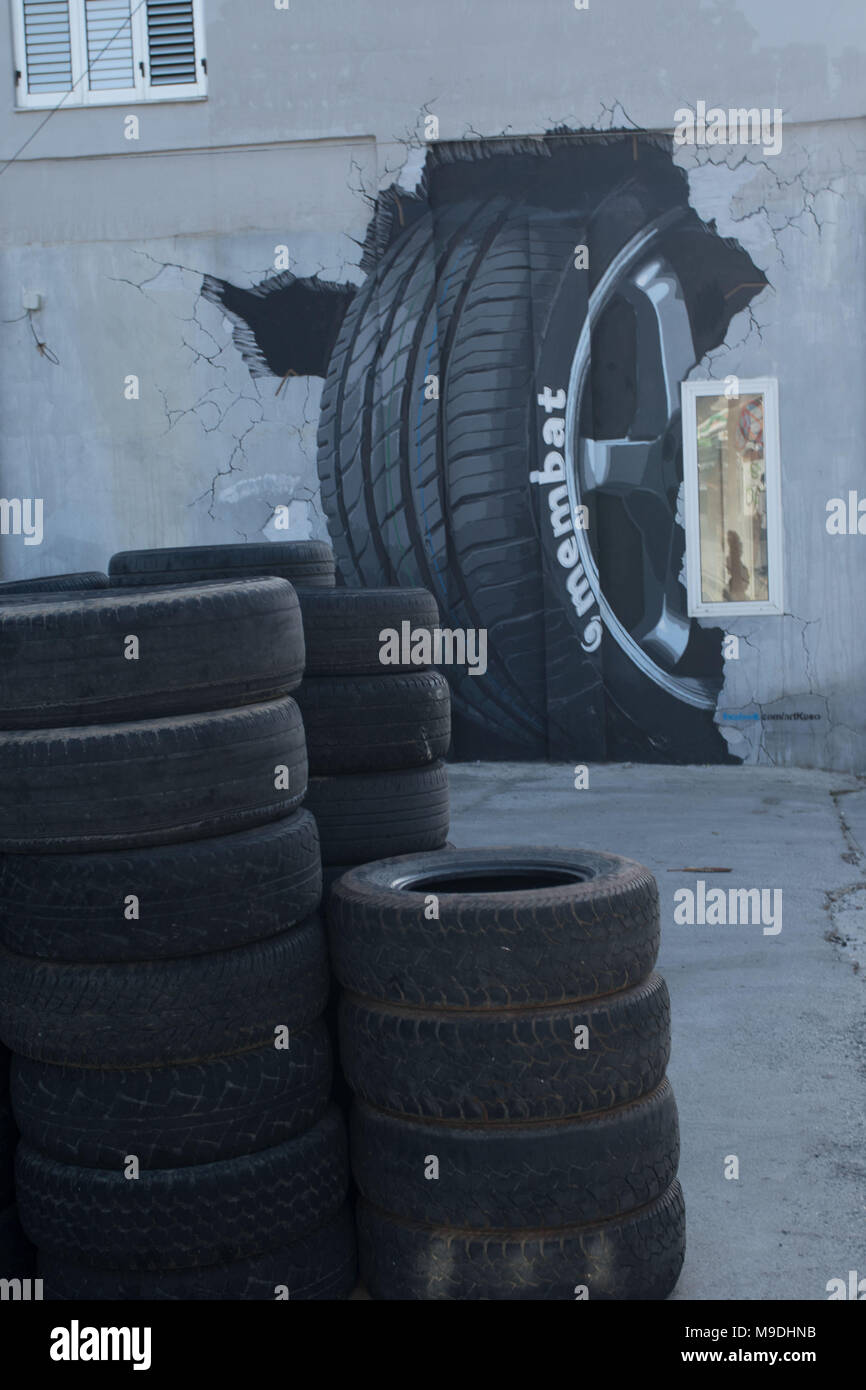 Stapel von Reifen und dreidimensionalen reifen Wandbild außerhalb der Werkstatt in der Altstadt von Paphos, Zypern, Europa Stockfoto
