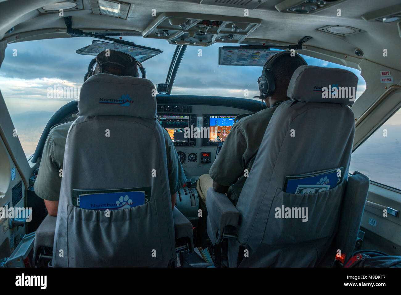 Cockpit Ansicht in Seite eine Cessna 208 Caravan im Flug, über die Serengeti, Tansania, Afrika. Stockfoto
