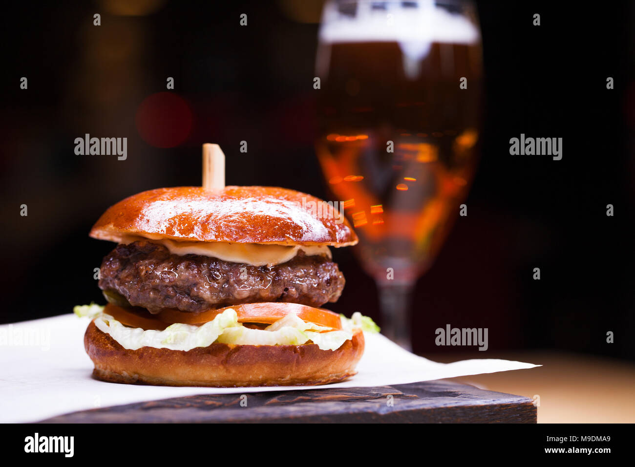 Leckere gegrillte Garnelen und Beef Burger mit Salat und Mayonnaise serviert auf ein Stück weißes Papier auf einem rustikalen Holztisch von Zähler, mit Copyspace Stockfoto