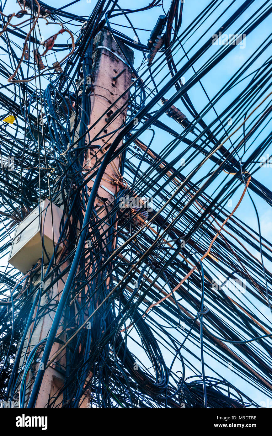 Riesige unordentlich Gewirr von Dutzenden von elektrischen Kabeln an der Spitze einer Strommast, Kambodscha Stockfoto