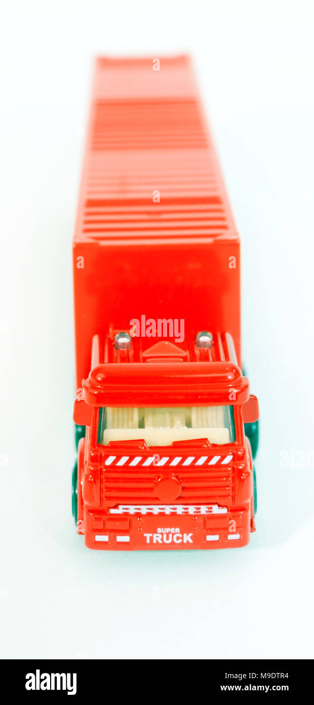 Aus rotem Kunststoff Spielzeug halb Lkw mit Anhänger container. Selektiver Fokus auf der Vorderseite der Kabine. Stockfoto