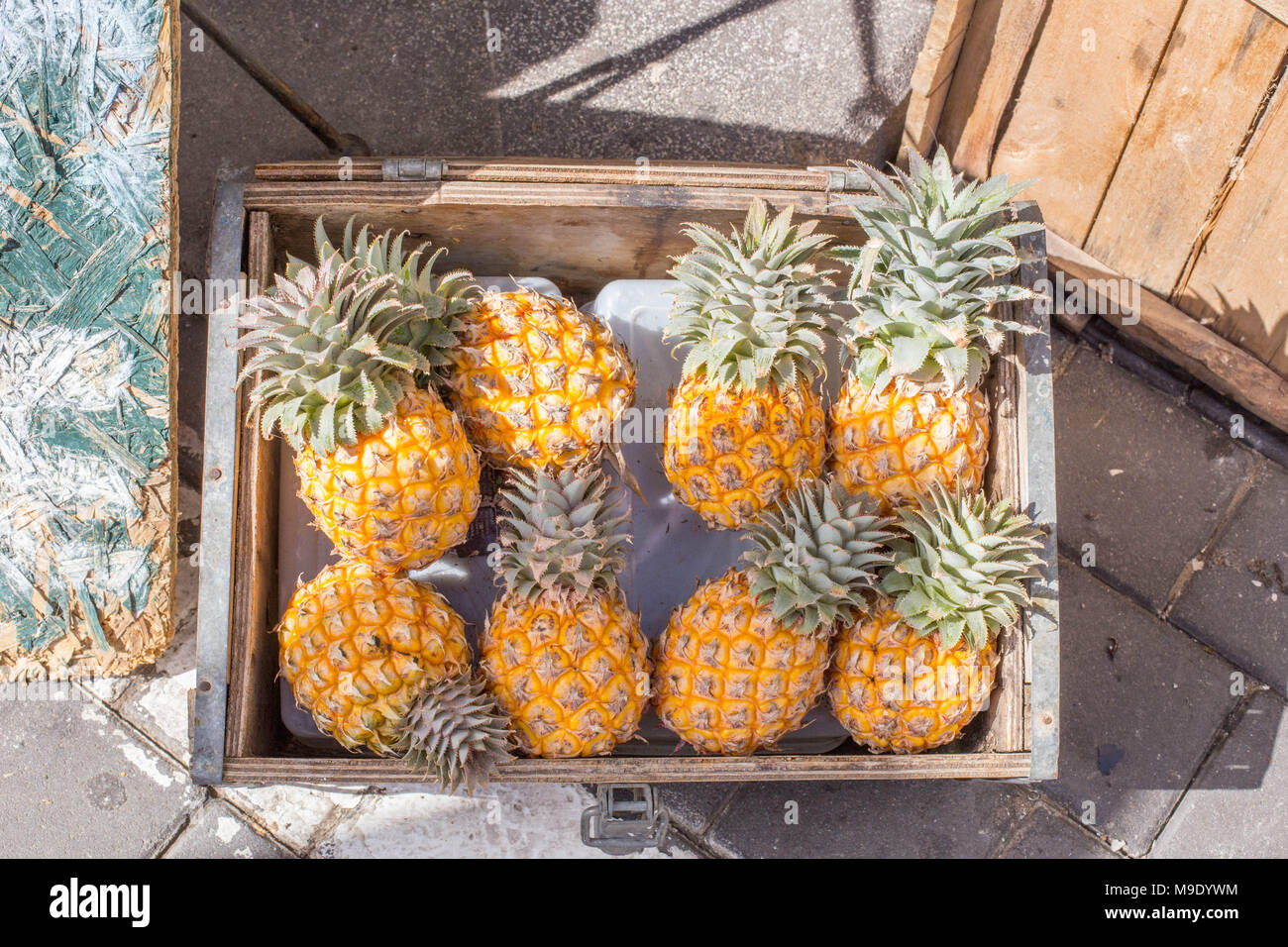 Ananas in einer Holzbox Sommer tropische Früchte natürliche Nahrung gelbe und grüne Blätter süß und gesund essen Bauern von oben Tageslicht Markt Stockfoto