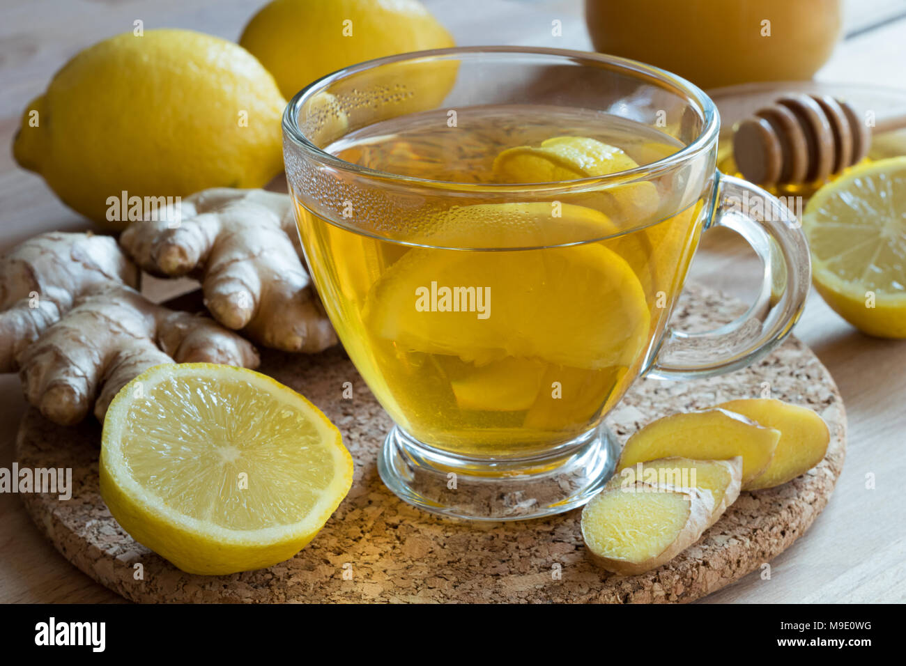 Ingwer Tee mit Zitrone, Honig und frische Ingwerwurzel im Hintergrund Stockfoto