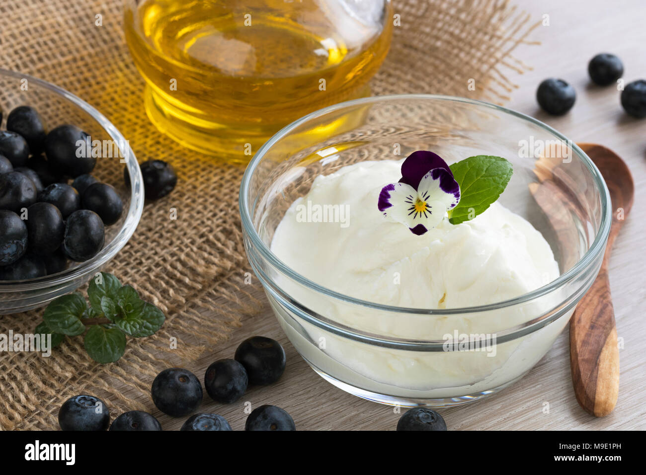 Quark mit Leinsamen öl, Blaubeeren und essbaren Blüten Stockfoto