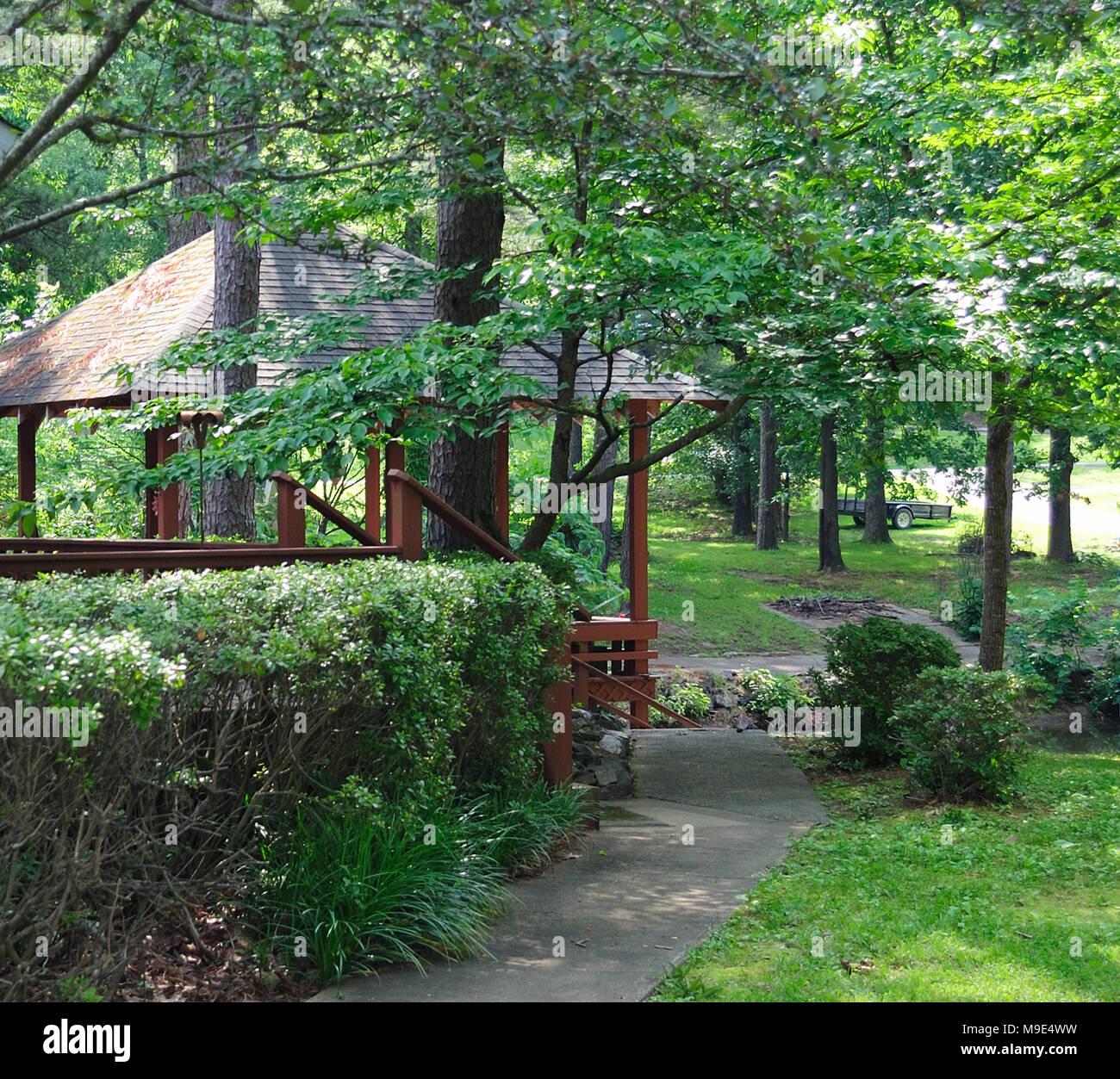 Überdachte Terrasse mit Pflanzen und Bäumen im Frühjahr/Sommer umgeben  Stockfotografie - Alamy