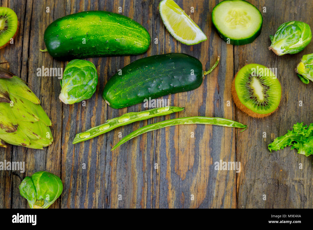 Frisches rohes Gemüse Zutaten für gesundes Kochen oder Salat mit rustikalen Olivenholz Brett in der Mitte, oben anzeigen, kopieren. Diät- oder vegetarische f Stockfoto