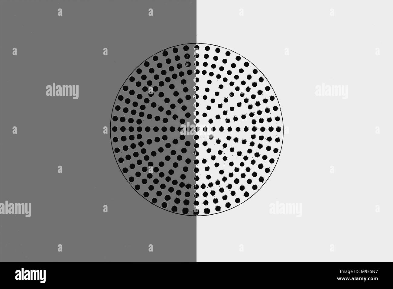 Metalloberfläche in Grau und Weiß lackiert. Schwarzer Kreis mit vielen kleinen Löchern in der Mitte perforiert. Industrielle Muster Stockfoto
