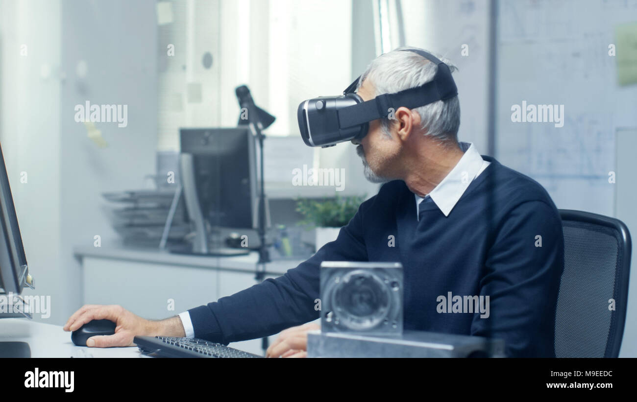 Virtual Reality Ingenieur arbeitet mit VR-Brille auf, während gleichzeitig tun Programmierung auf seinem PC. Stockfoto