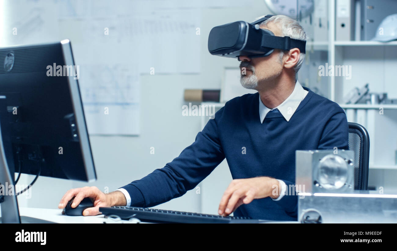 Virtual Reality Ingenieur arbeitet mit VR-Brille auf, während gleichzeitig tun Programmierung auf seinem PC. Stockfoto