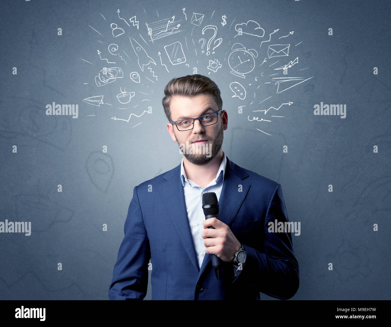 Geschäftsmann sprechen in das Mikrofon mit gemischten Doodles über seinem Kopf Stockfoto