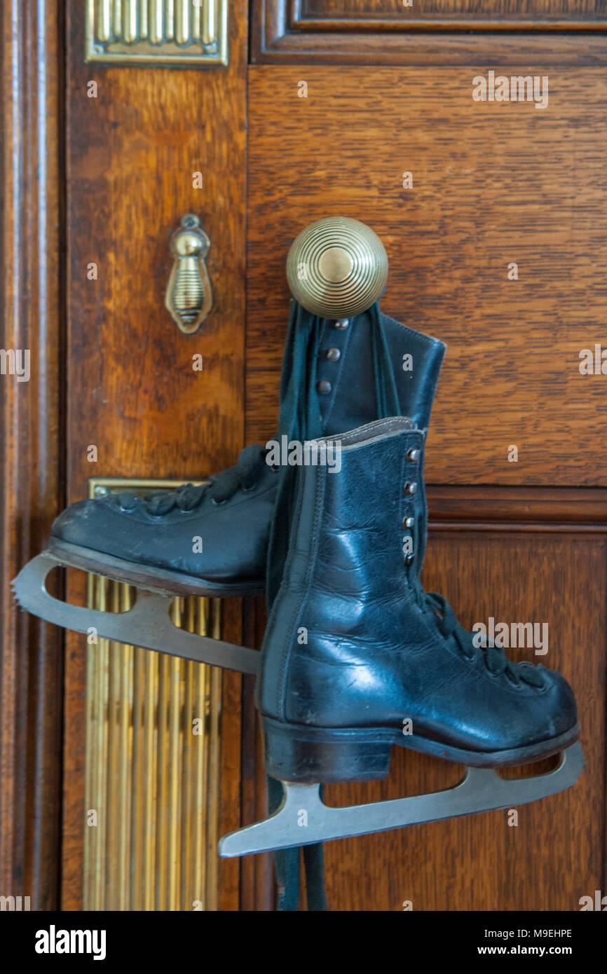 Einige alte Kinder oder Damen Schlittschuhe hängend an einer Tür in einem viktorianischen Haus Griff Stockfoto
