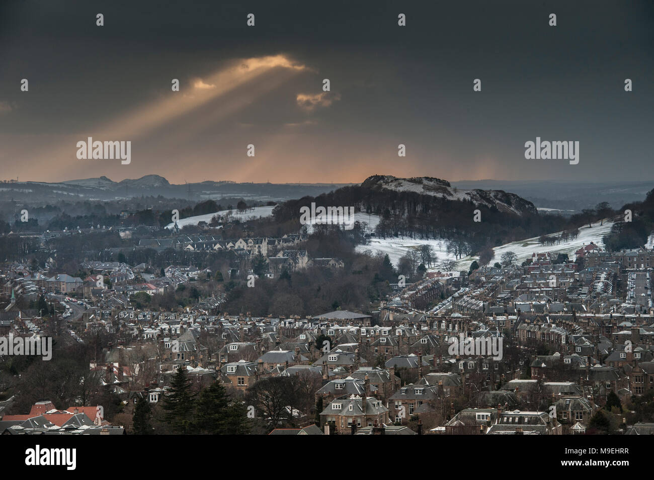 Ein Blick von hoch oben über Edinburgh in der Hälfte licht West suchen mit Lichtstrahlen durch die schwere schwarze Wolken brechen Stockfoto