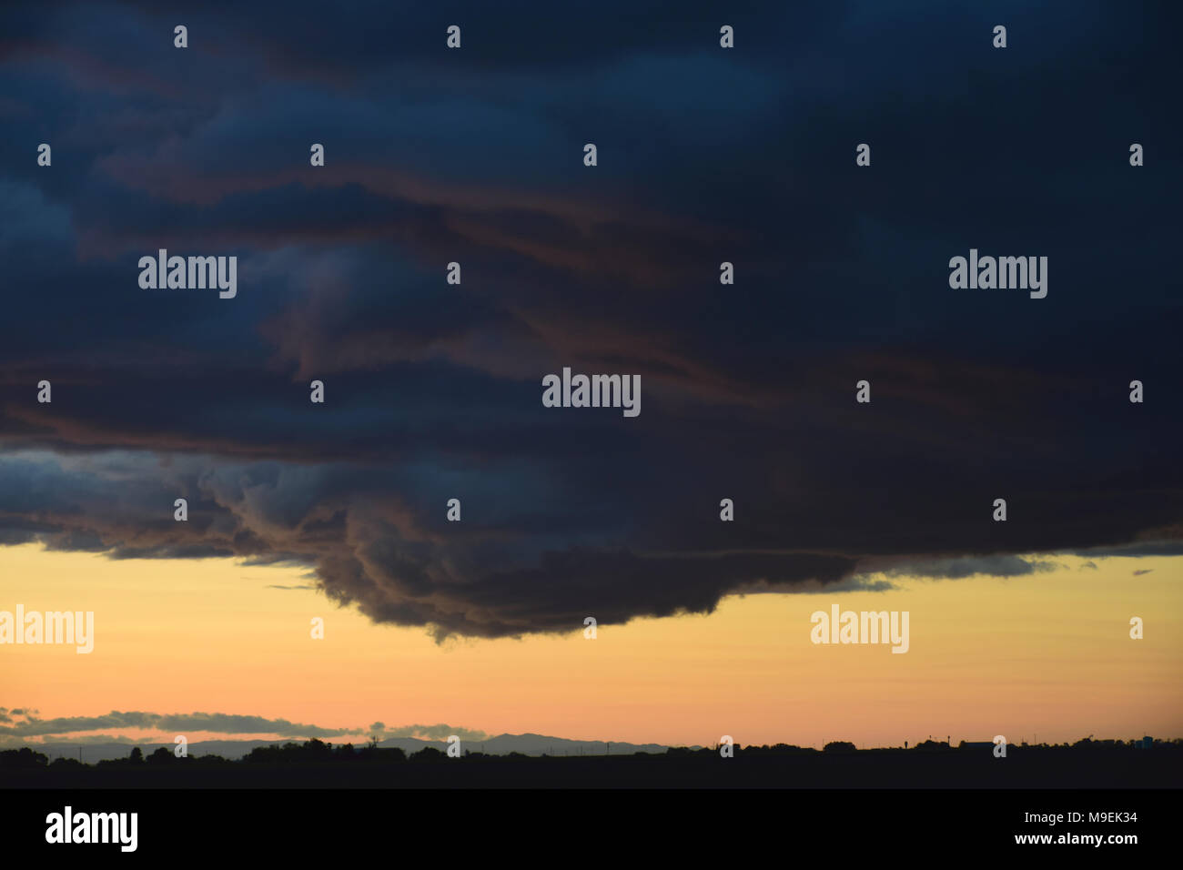 Dunkle Wolken in einem stürmischen Himmel bei Dämmerung Stockfoto