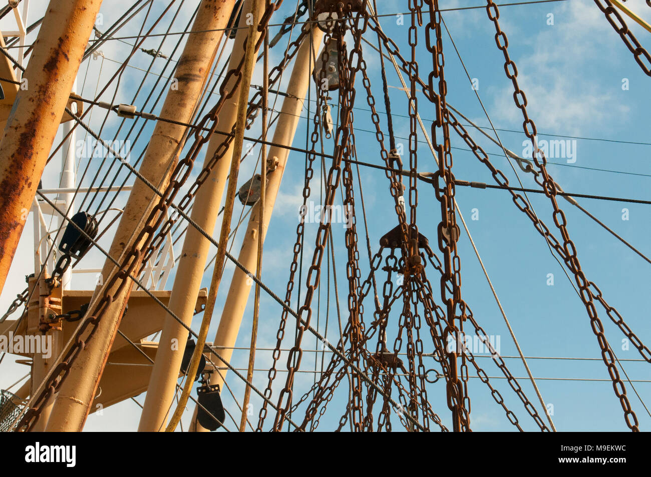 Rostige Ketten hängen von der Mast eines großen fischtrawler Boot. Stockfoto